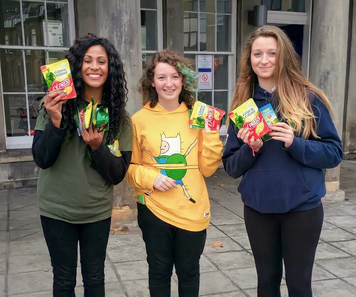 Three Green Giant brand ambassadors on a city street holding up packs of Green Giant Express Sweet Corn