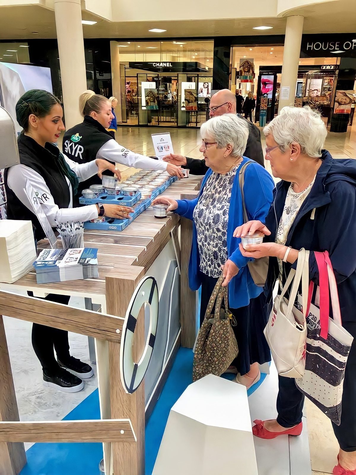 Arla Skyr brand ambassadors handing samples across a branded counter to shoppers in a shopping centre