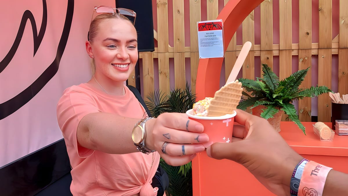 A Three team member handing a complimentary ice cream to a guest