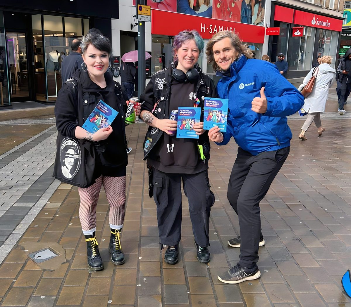 Northern brand ambassador giving a thumbs up with members of the public on a high street