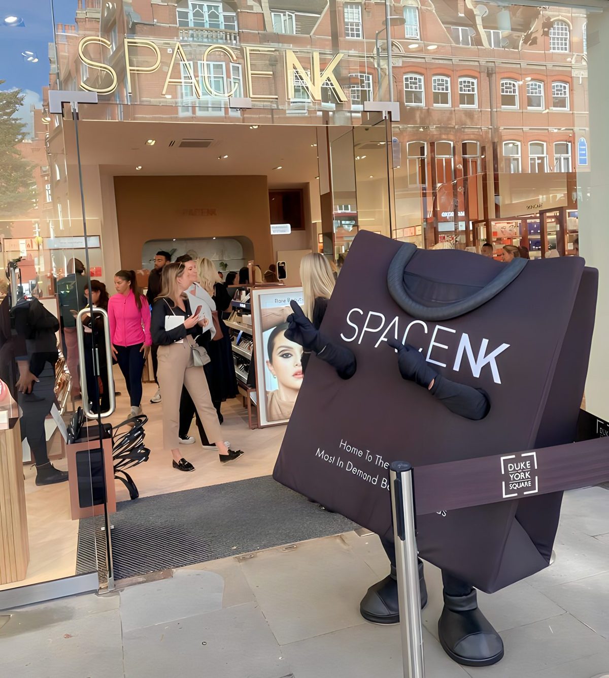 Promotional staff in Space NK mascot costumes handing out lollipops in store