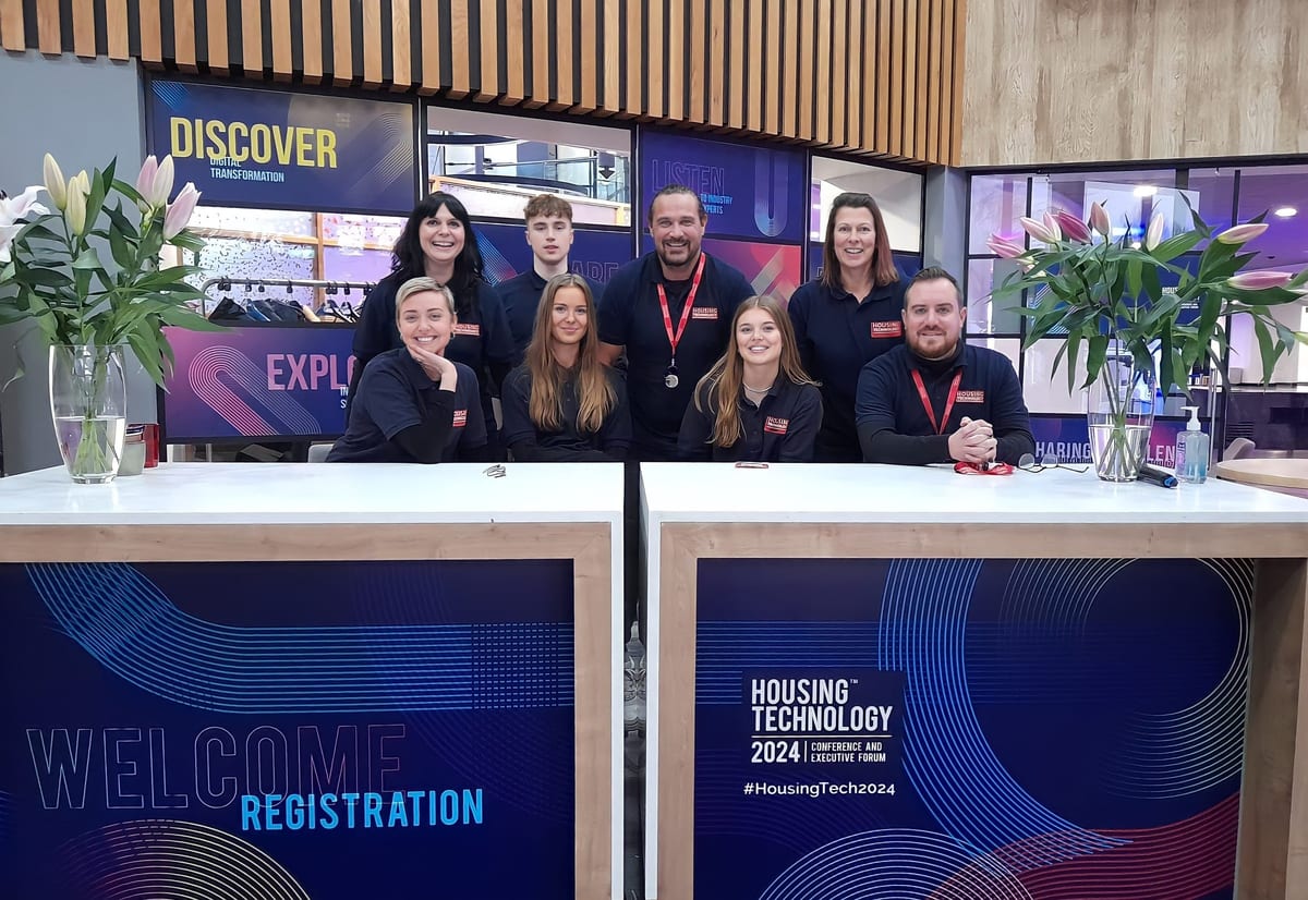 Executional team at a registration desk welcoming conference delegates