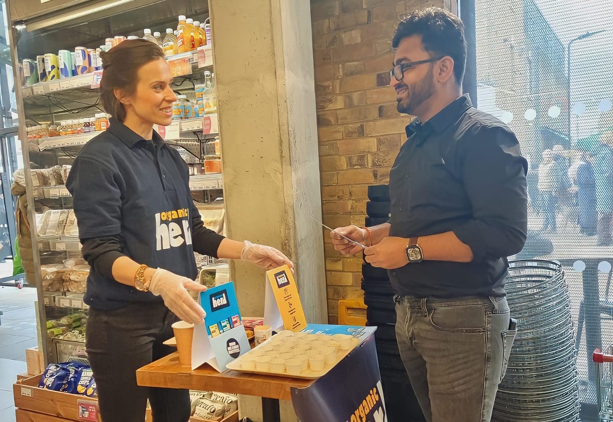 EXECUTIONAL tasting host talking a customer through Organic Herd at a Planet Organic counter