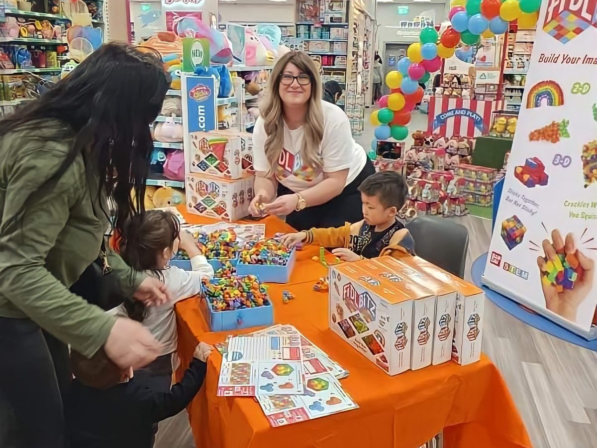 Bandai FidlBitz demonstrator showing the toy to children at a store table