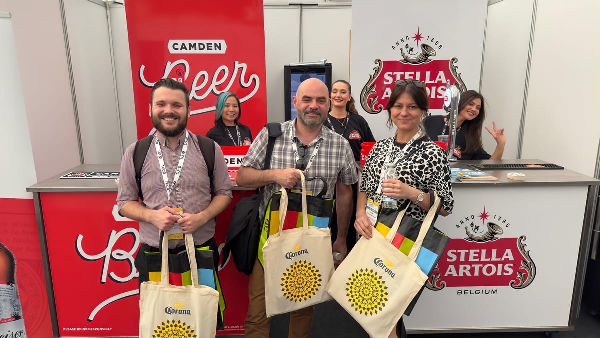 Event staff handing out bags to visitors at a conference stand