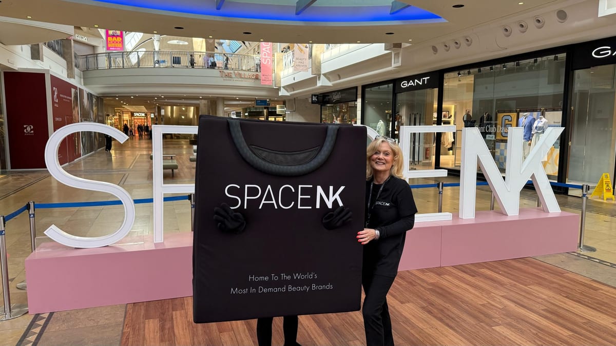 EXECUTIONAL team member beside a brand display in a UK store