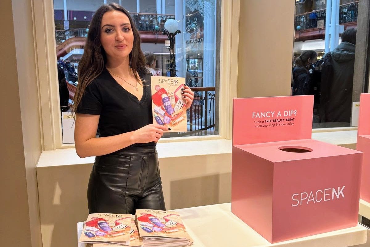 Staff member beside a Space NK display at a store opening