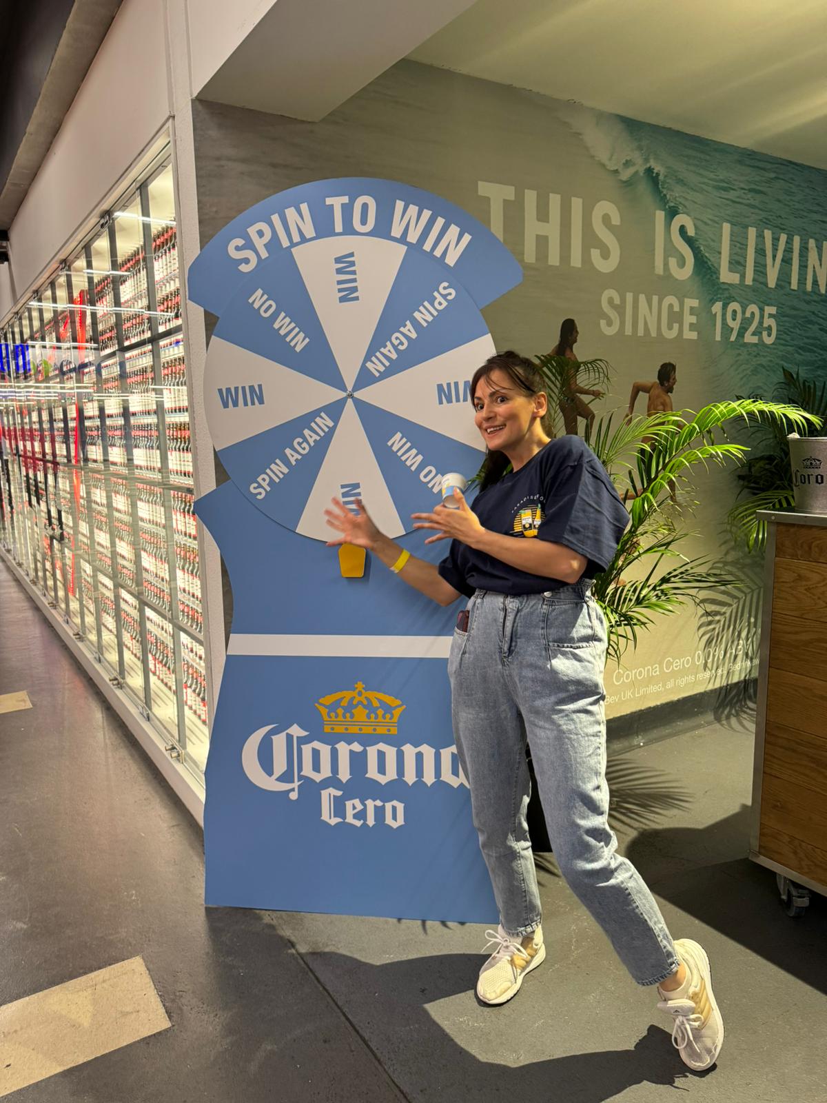 Promotional staff beside a Corona Cero spin to win game in store