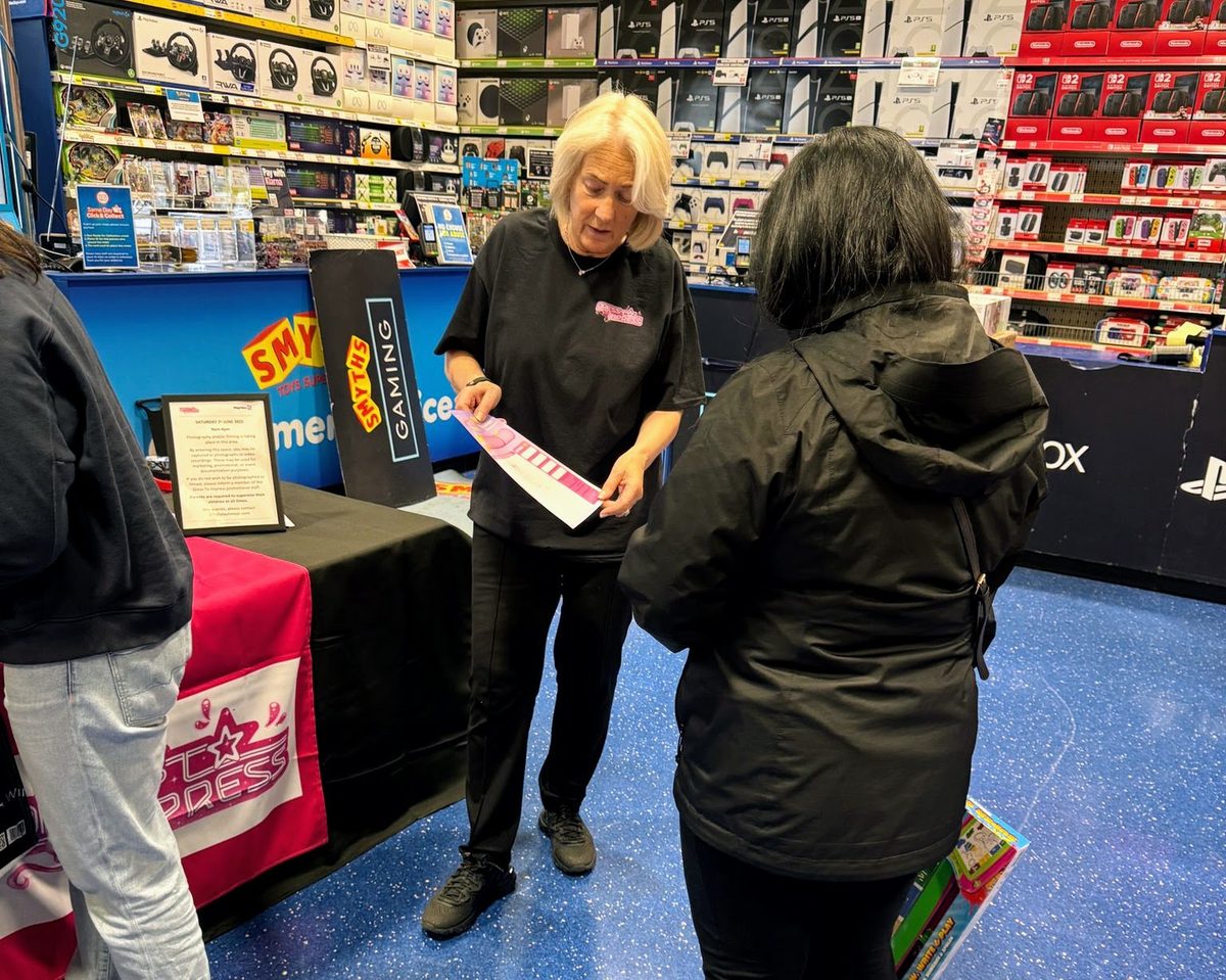 Promotional staff showing a new product to shoppers in a toy store