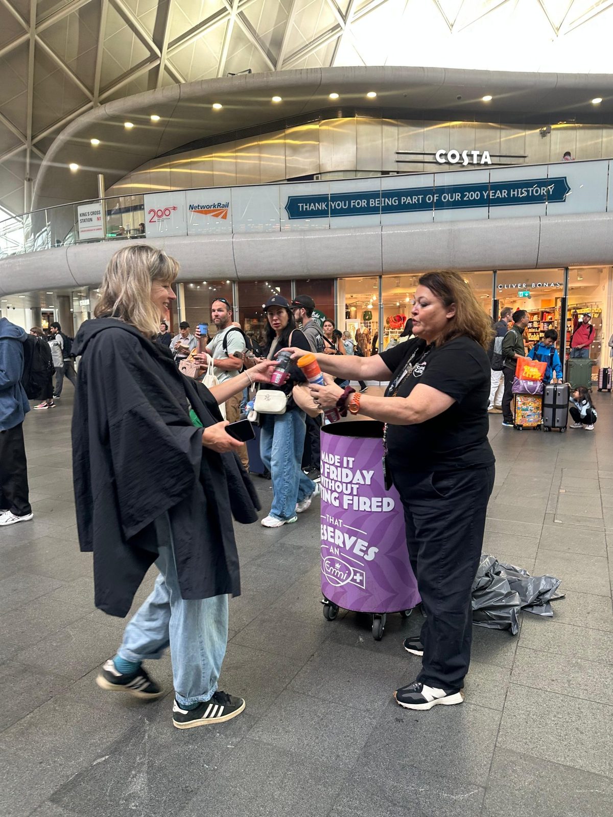 Brand ambassadors in uniform sampling Emmi Caffè Latte at King's Cross Station