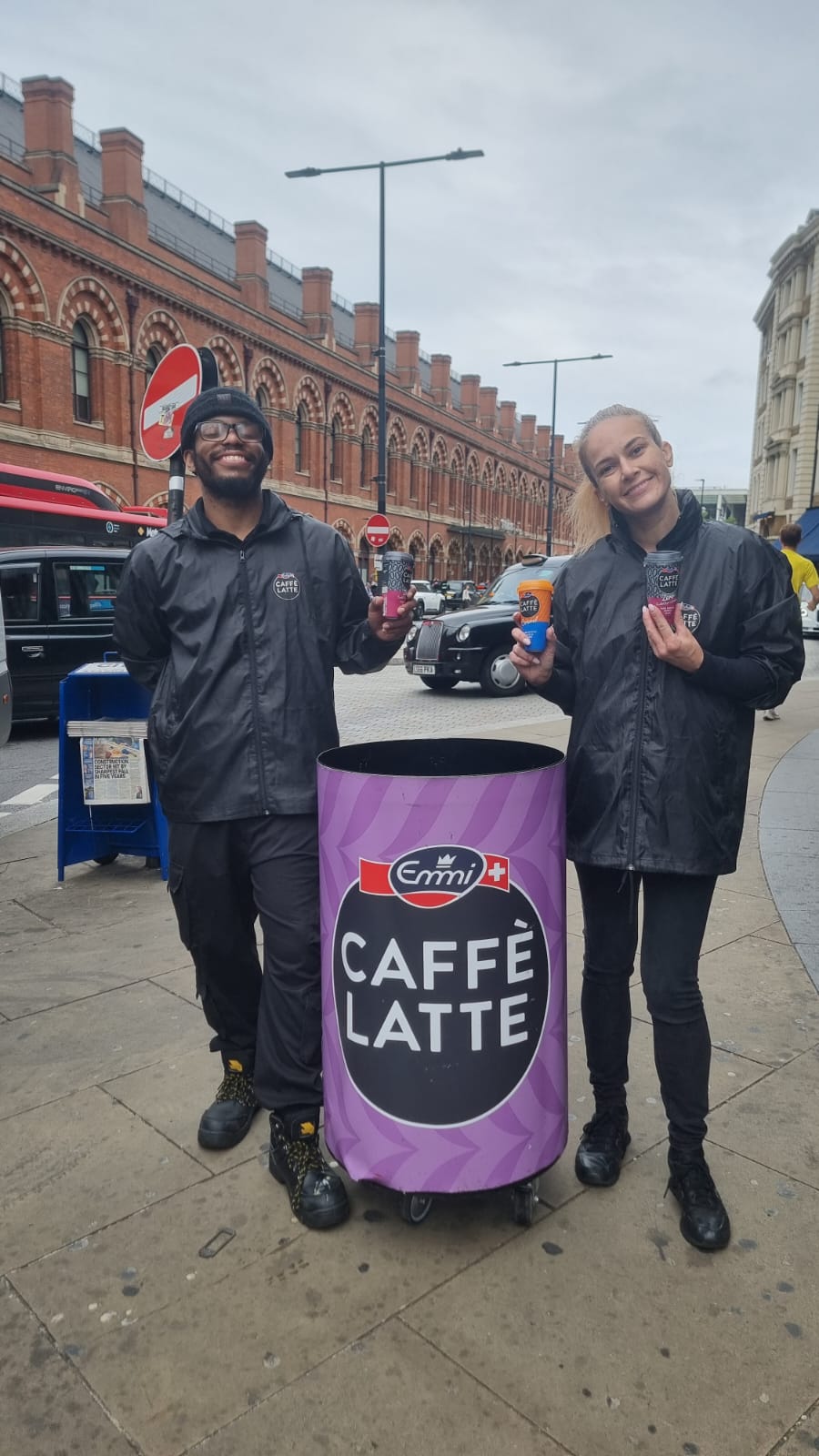 staff beside branded sampling bins on a London station concourse