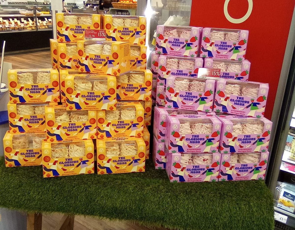 sampling staff offering mini meringues to shoppers in a Booths store