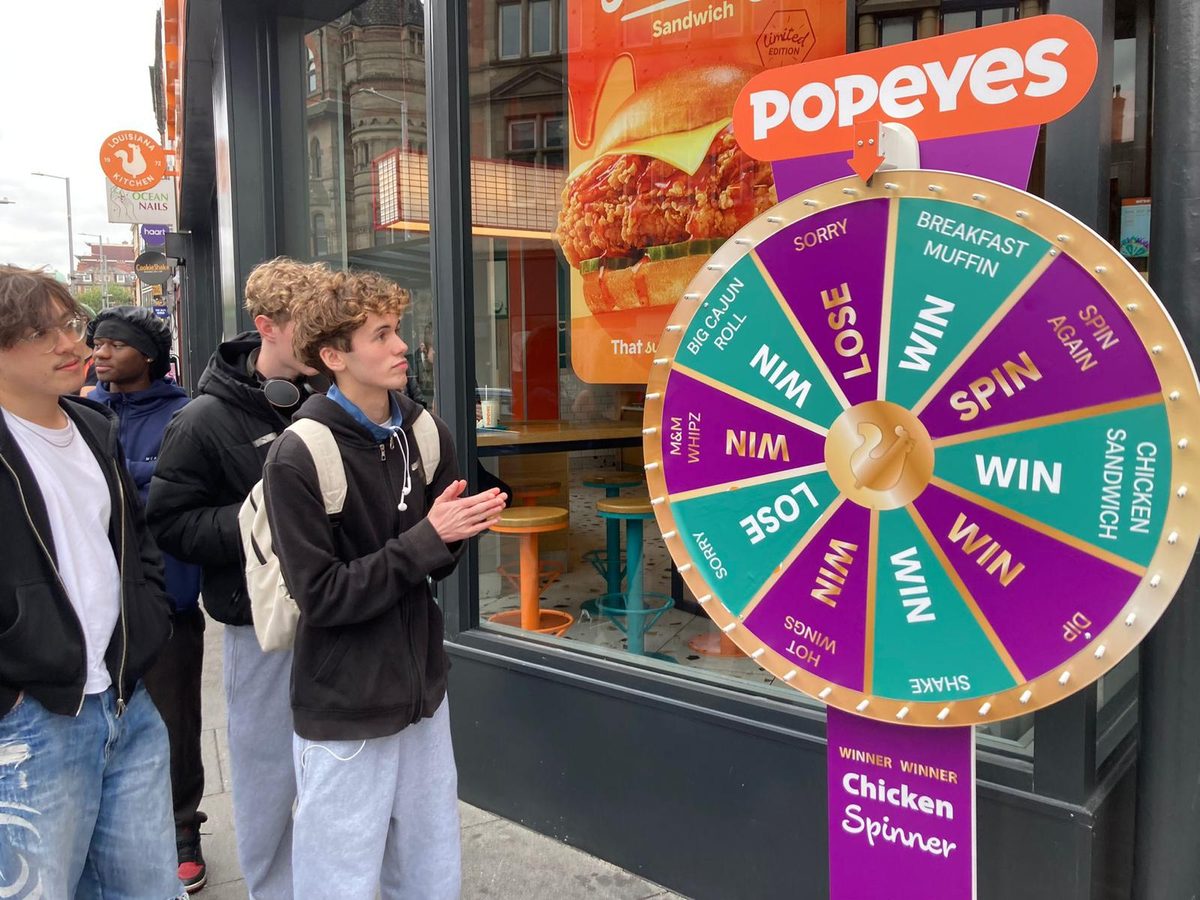 Executional activation team leader with a brand ambassador at a Popeyes spin to win
