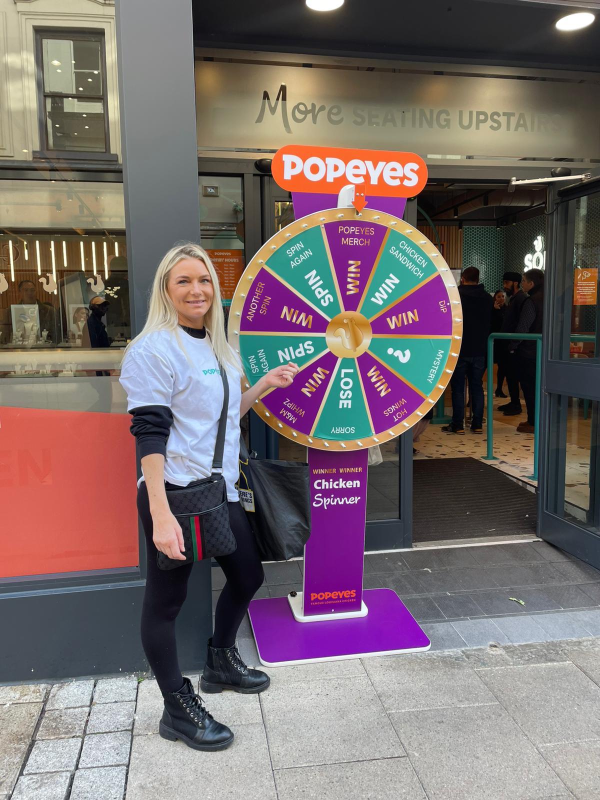 Brand ambassadors running the Spin to Win wheel for Popeyes