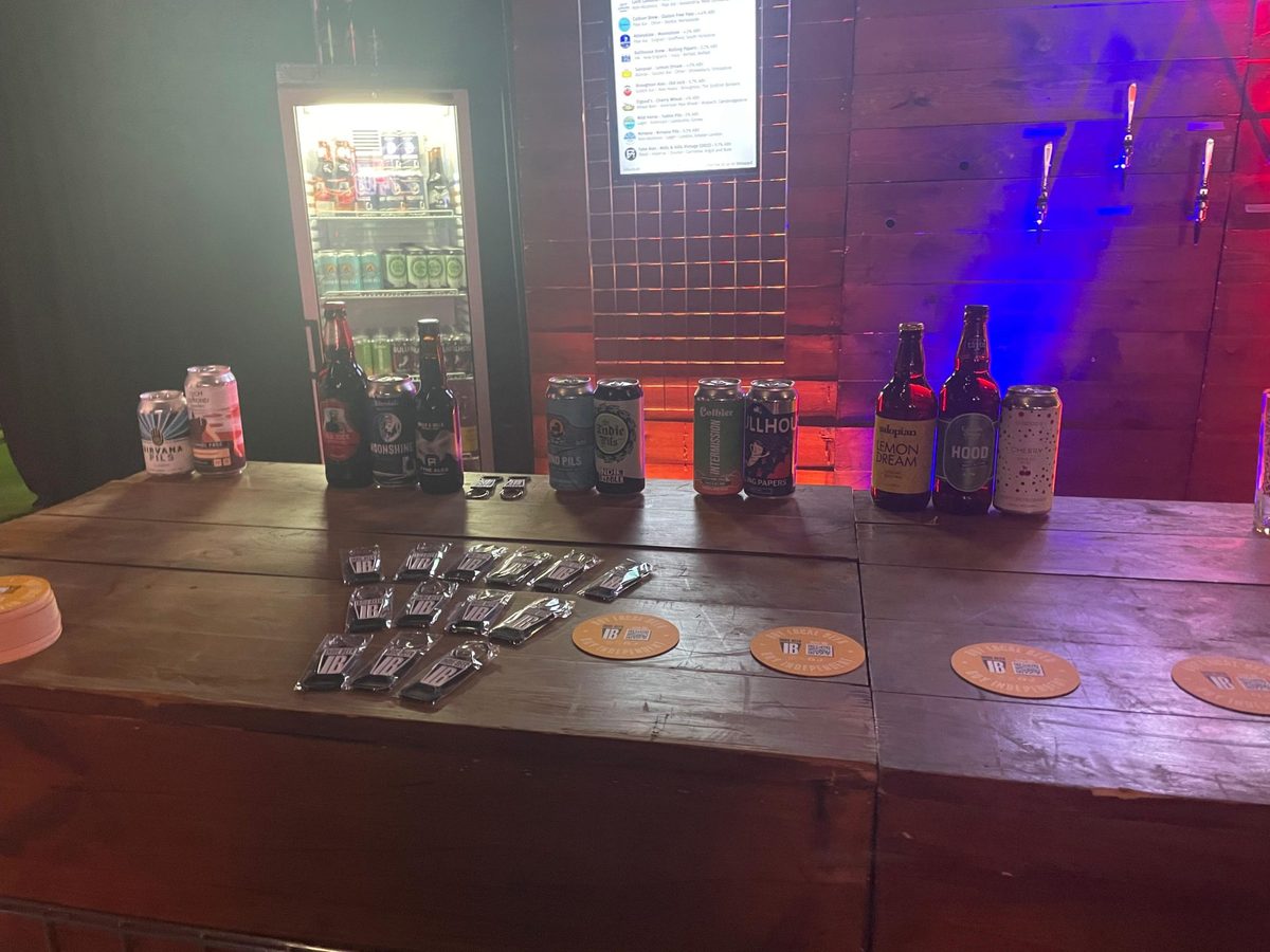 Event staff serving pints behind a branded bar at the pub awards