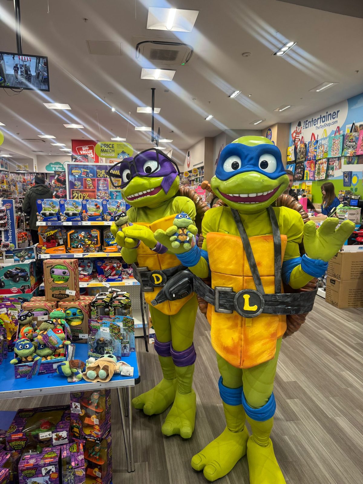 Costume character dressed as a Ninja Turtle greeting children inside The Entertainer in Glasgow