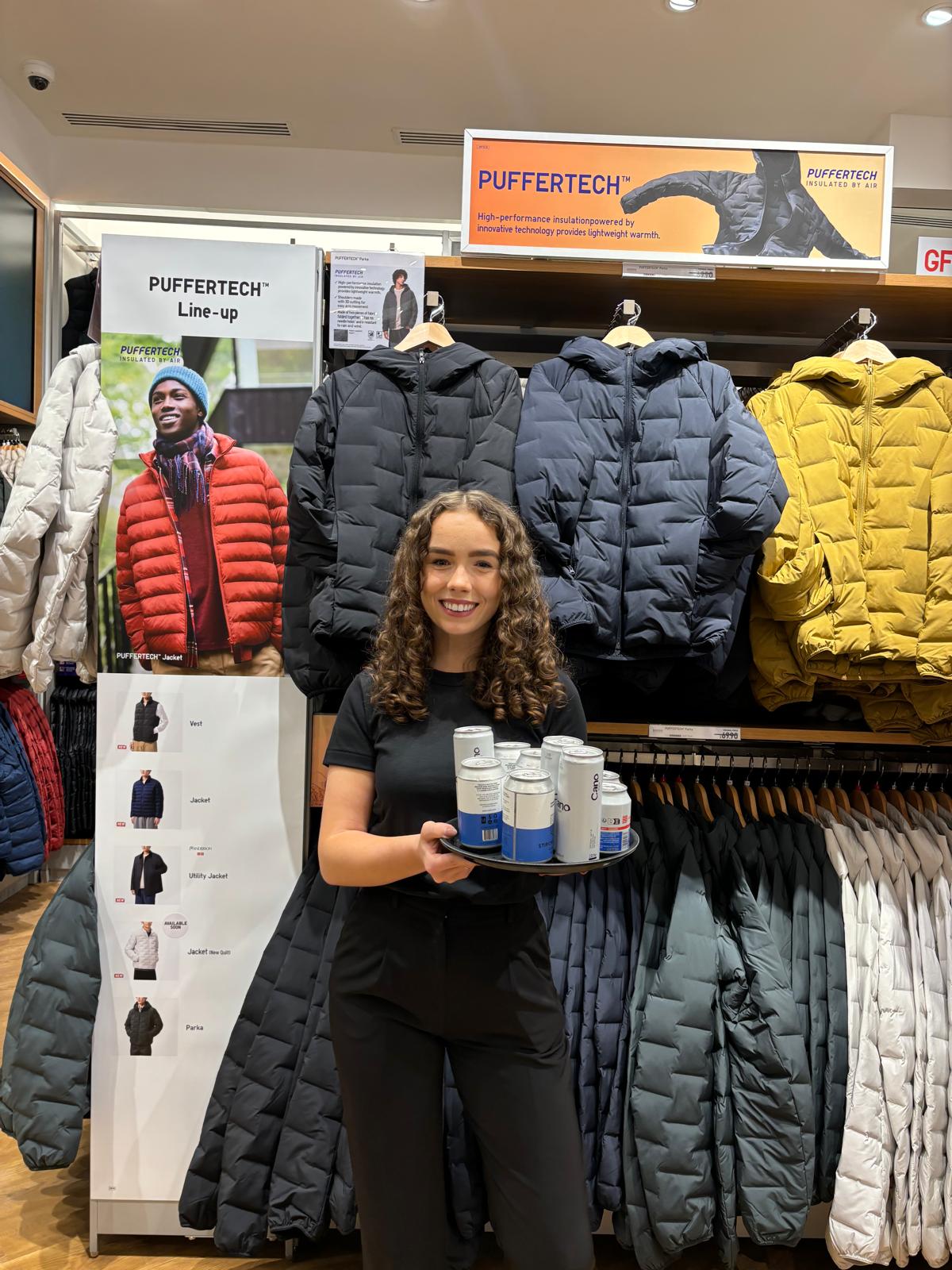 Staff member holding products beside the coat rails in the UNIQLO store in Birmingham