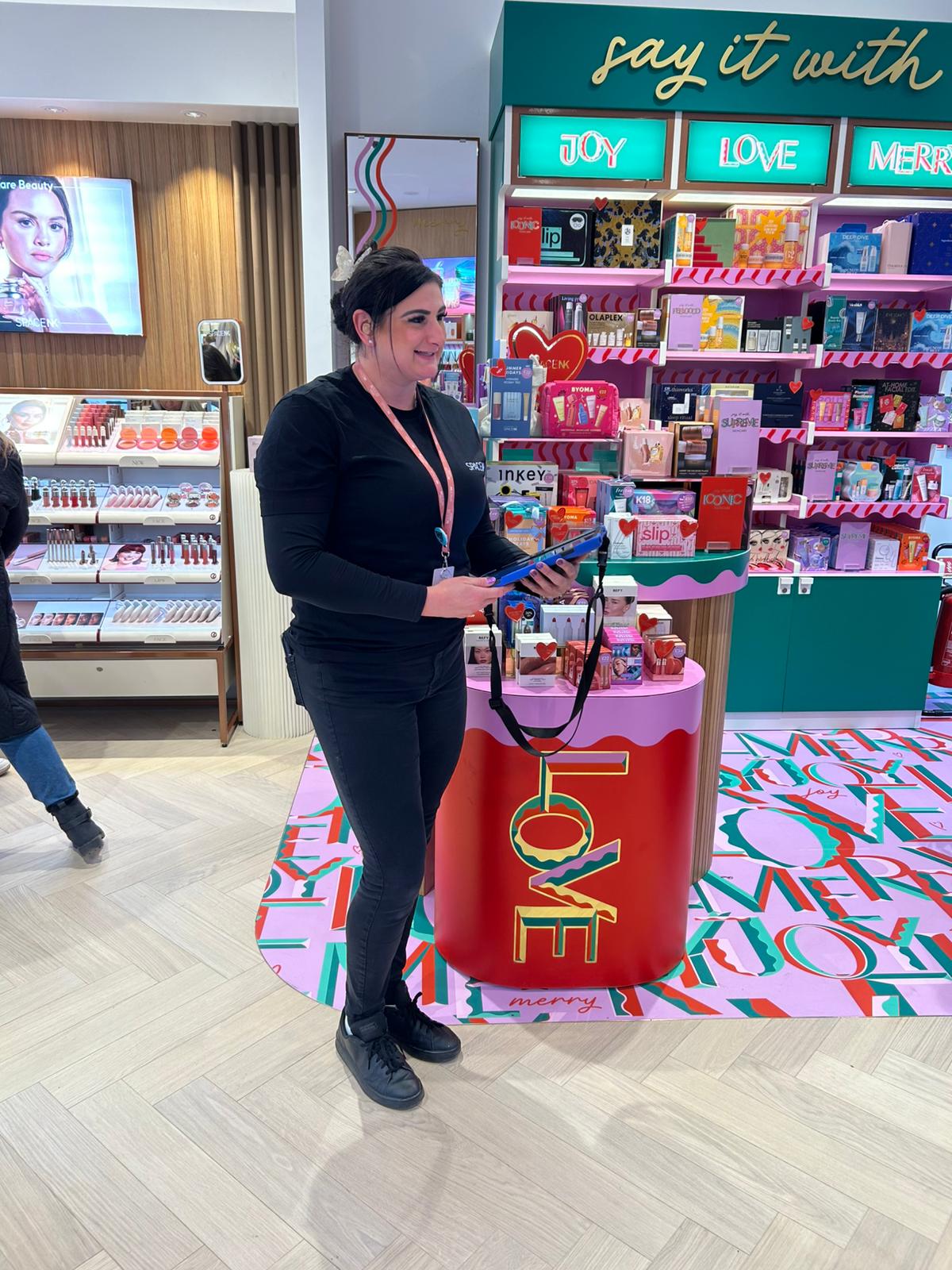 Staff member beside a gift display in the Space NK store in Canterbury