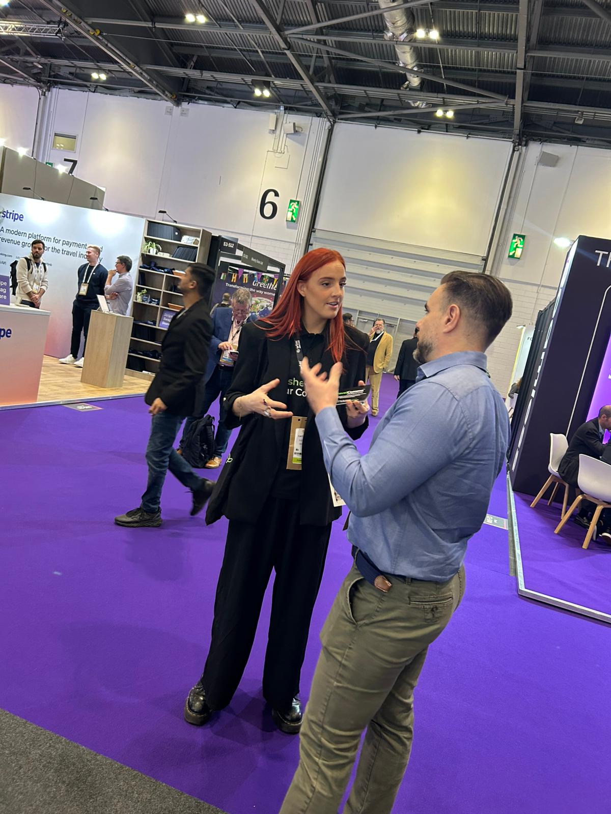 Executional sales support staff talking to a visitor on a trade stand