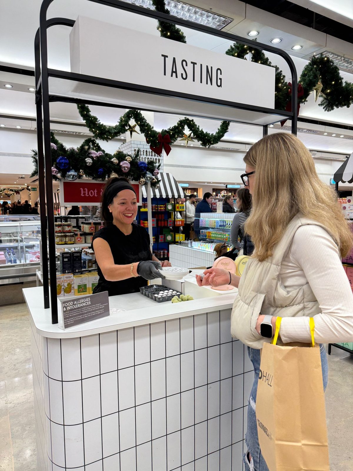 Sampling staff at a Charbonnel et Walker truffle tasting station in a retail store
