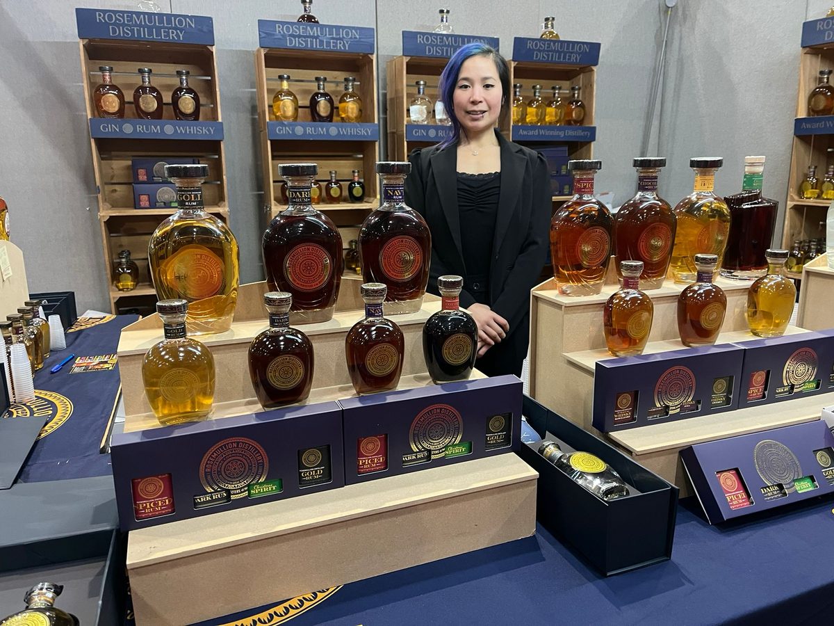Exhibition staff selling bottles of Rosemullion gin and rum from a trade stand