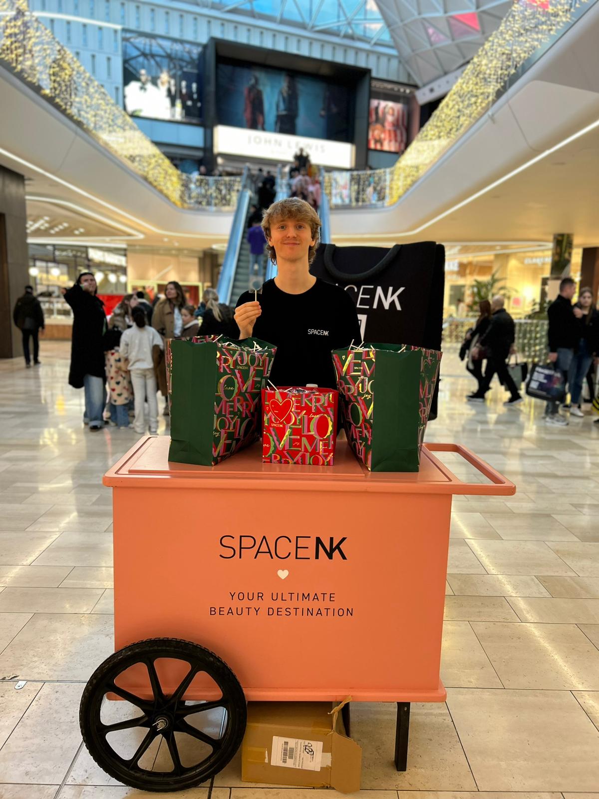 Promotional staff with a Space NK gift cart in a shopping centre