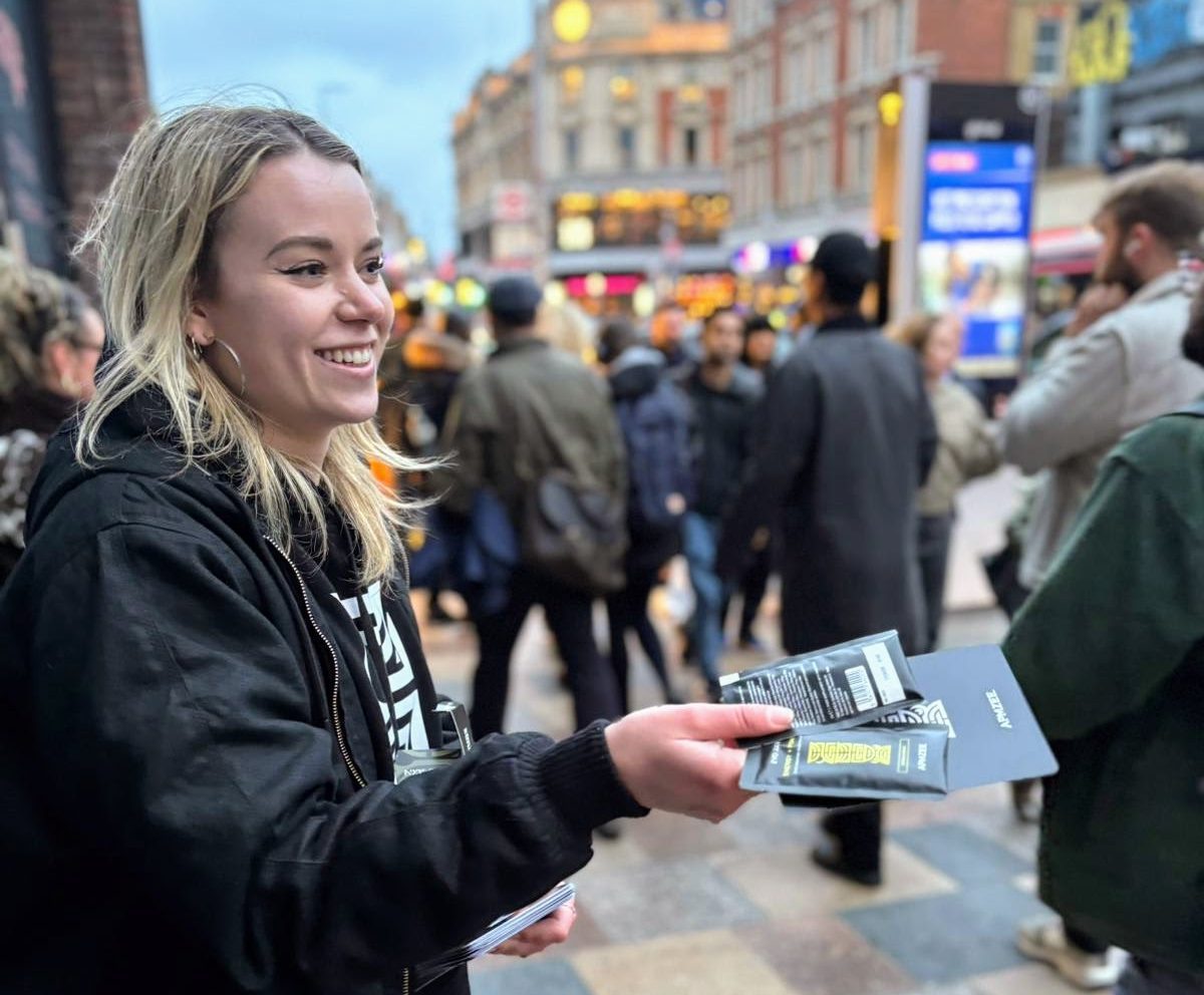 APMZEE street team member handing out samples on a busy London street