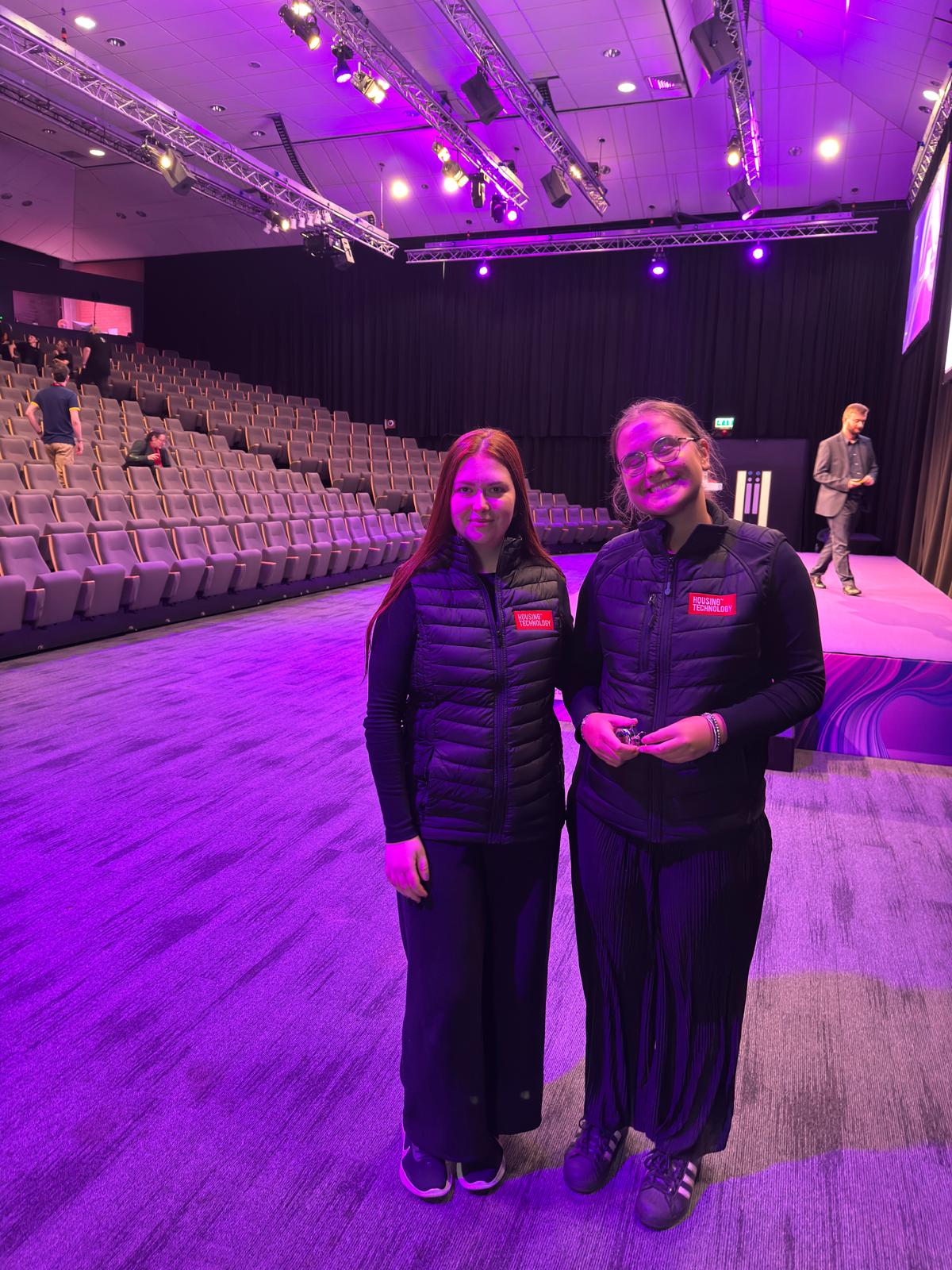 Two conference hosts in the main auditorium before a session in Nottingham