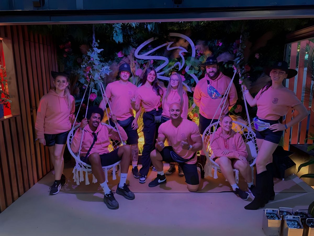 Event team in matching pink tops at an evening event