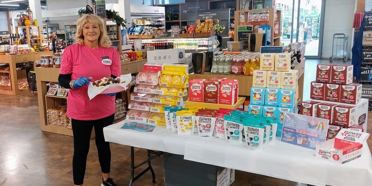 Flower & White promotional staff member at a sampling stand in an Edinburgh shopping centre