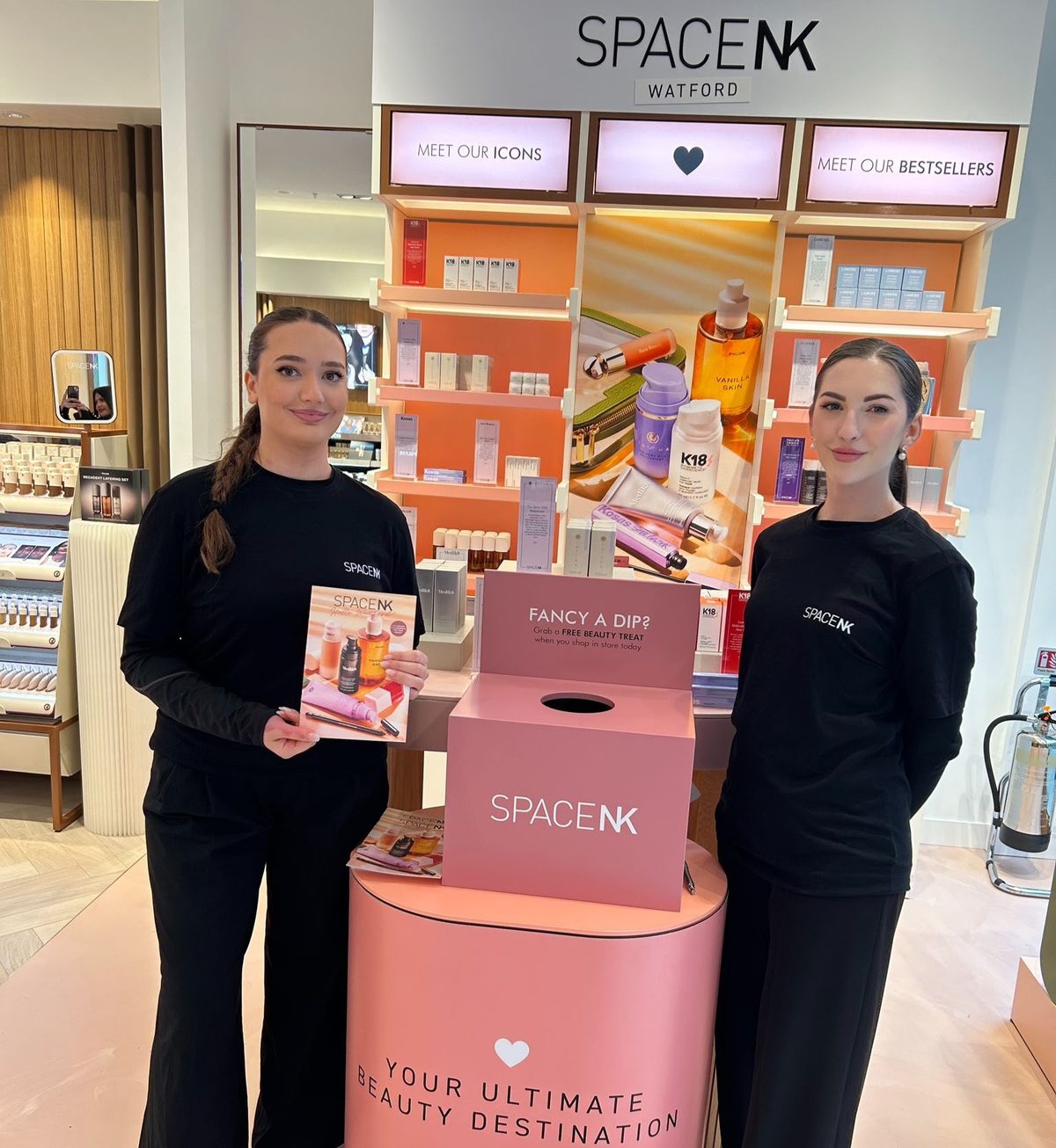 Two staff beside a promotional display at the Space NK store in Watford