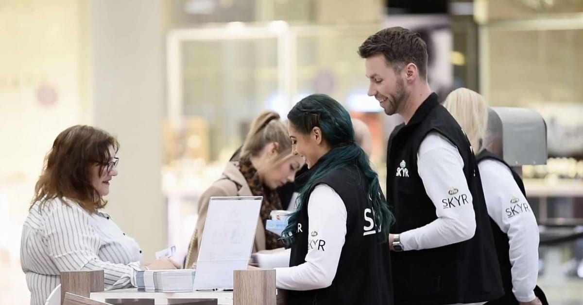 Event staff in matching branded gilets setting up at a registration desk