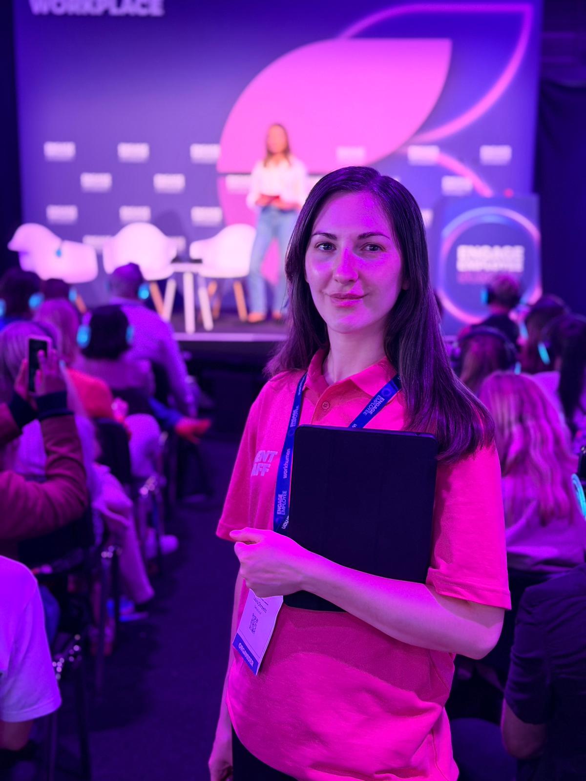 Conference host with a folder in a session room at the Engage Employee Summit in London