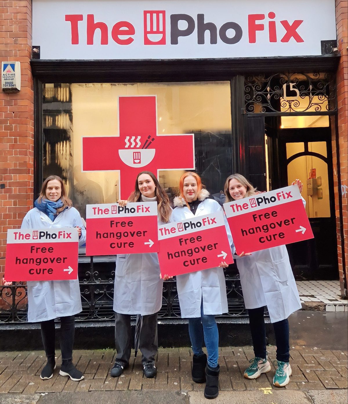 Executional promotional staff holding signs outside The Pho Fix in Leicester