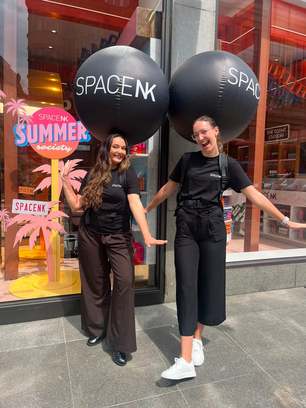 Two staff in black outside a Space NK store for a launch