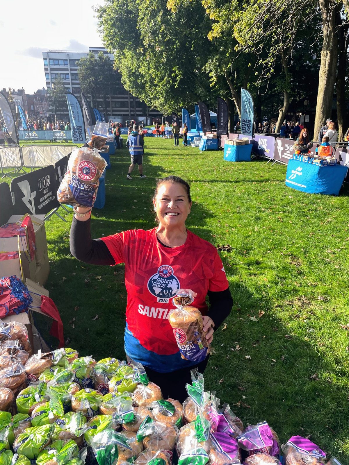 Ambassadors handing New York Bakery finisher bags to runners at Bank Park in Warrington