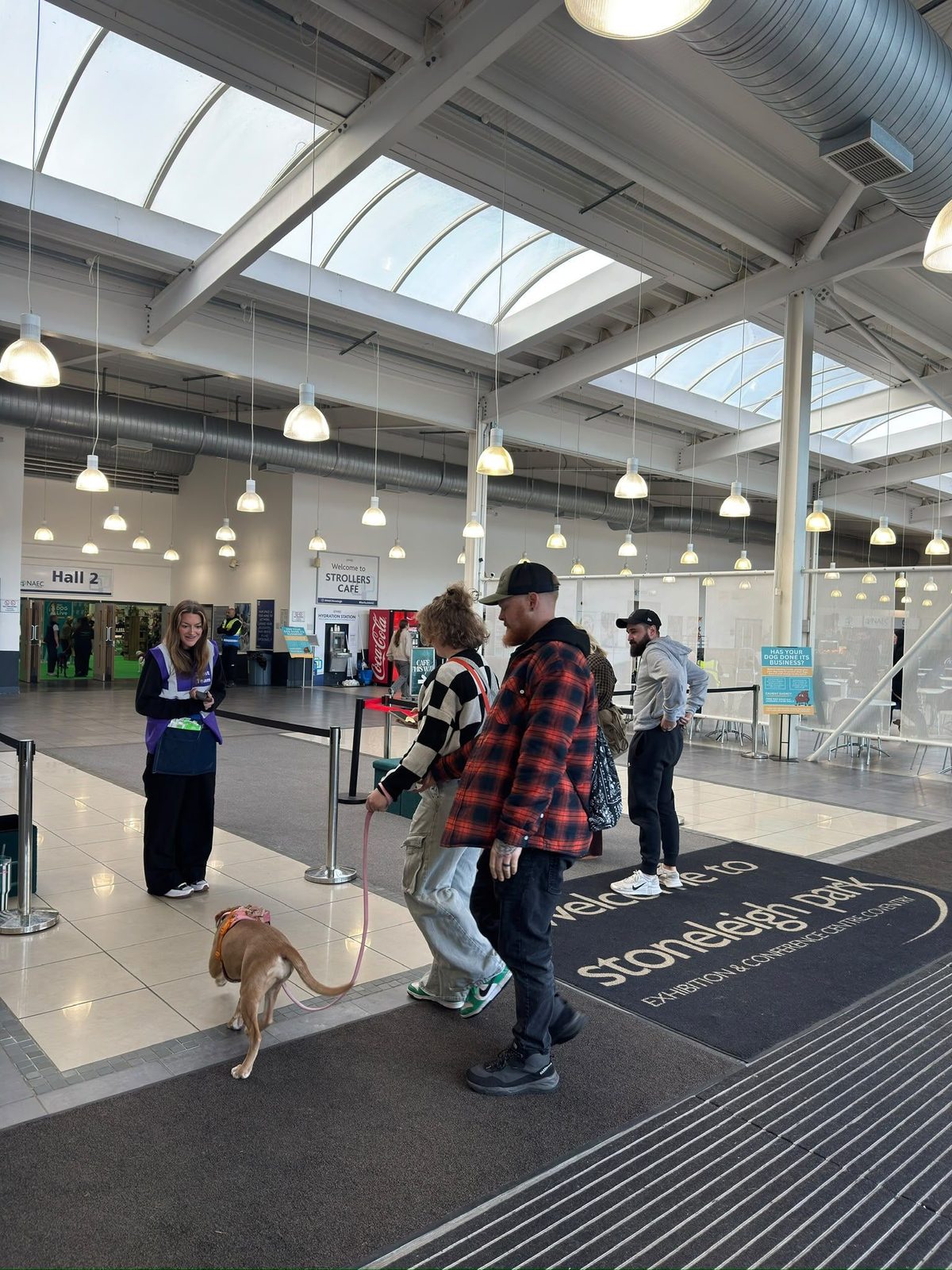Dog owners arriving at Edition Dog Live past the welcome team in the foyer