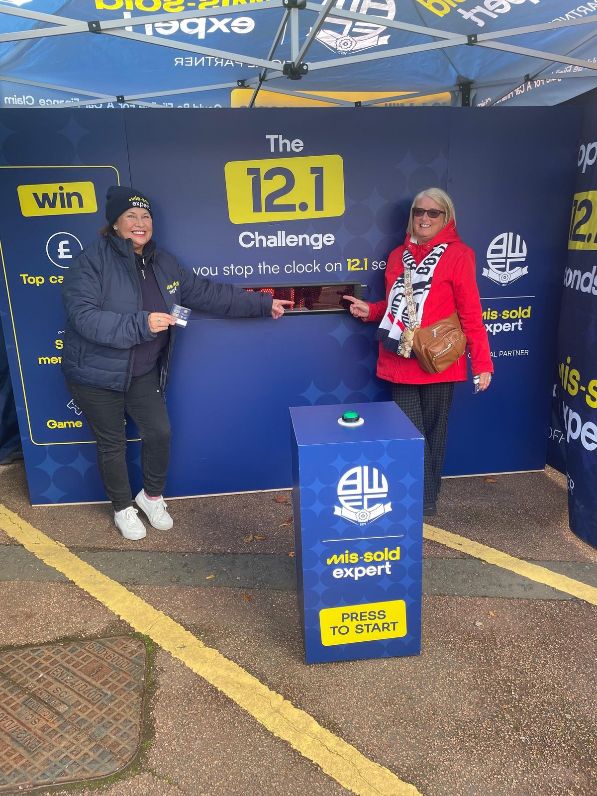 Brand ambassador and a Bolton fan at The 12.1 Challenge booth outside Bolton Wanderers Stadium