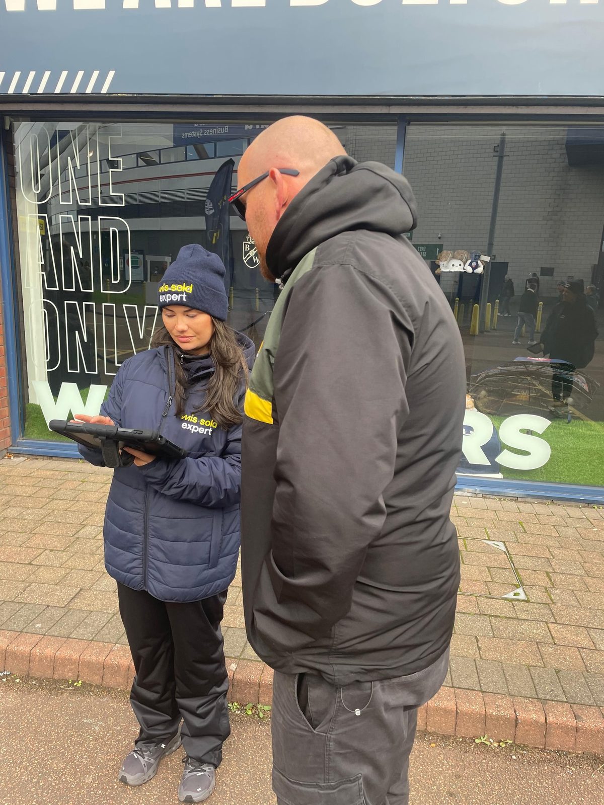 Brand ambassador talking a fan through the free eligibility check on an iPad at Bolton Wanderers