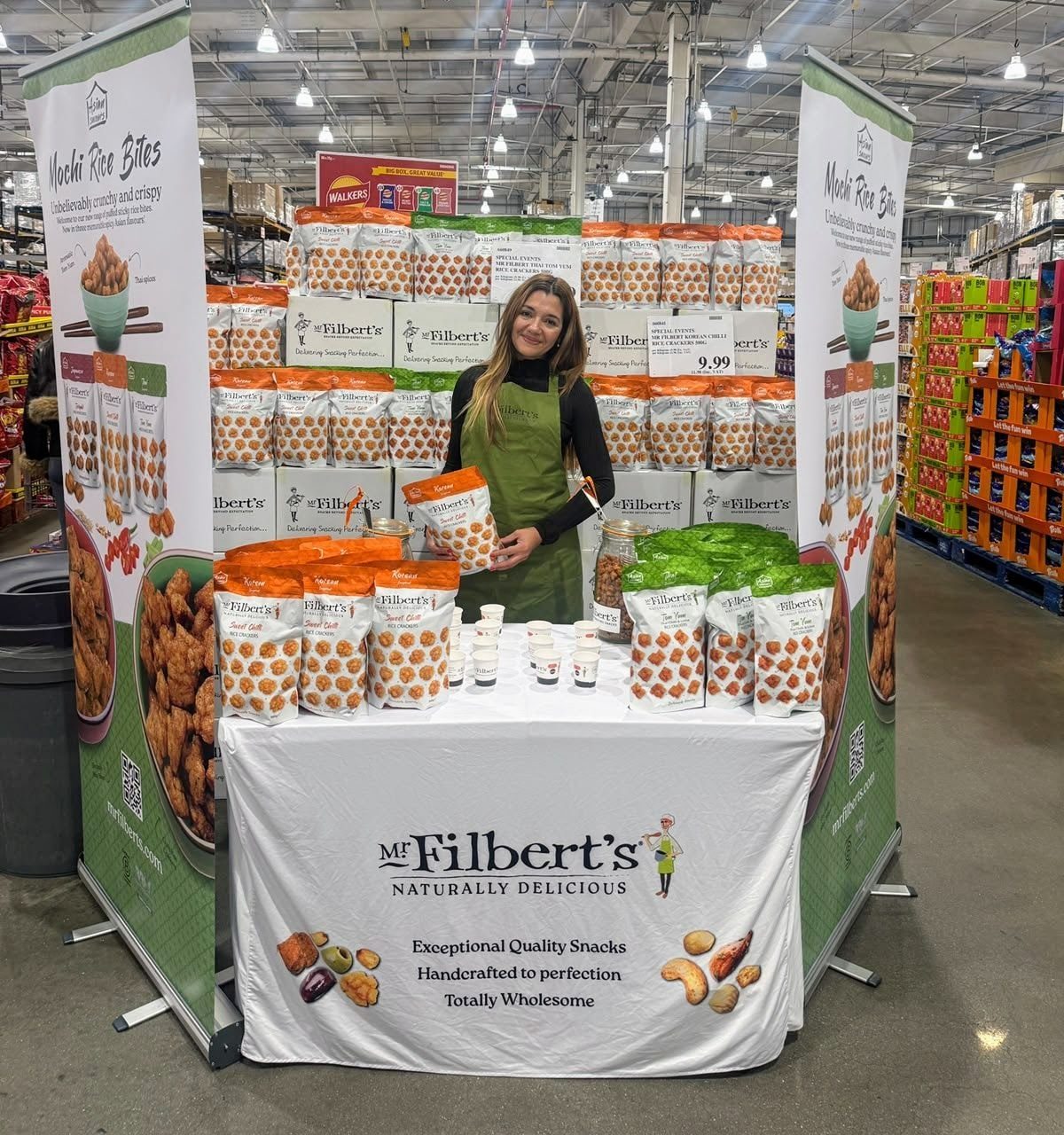 Brand ambassador holding a bag of Mr Filbert's Asian Savours rice snacks at Costco Thurrock