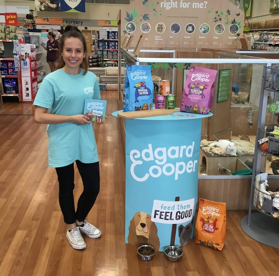 EXECUTIONAL team member beside an Edgard and Cooper display in a pet store