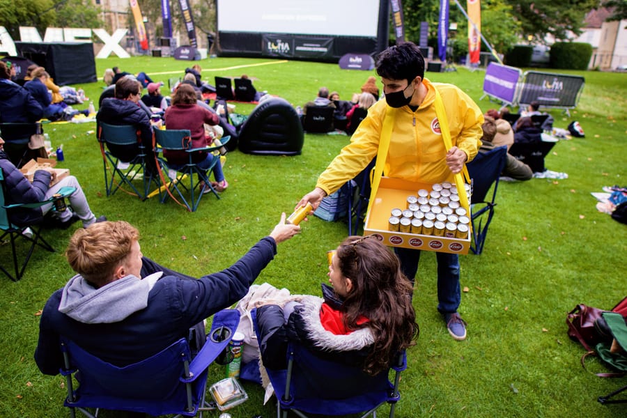 EXECUTIONAL sampling staff handing Cocio chocolate milk to an audience at an open-air screening