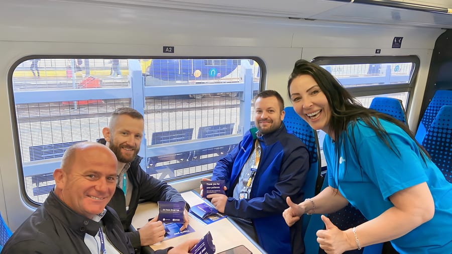 EXECUTIONAL promotional staff talking to Northern passengers at a table on board a train