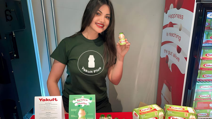 EXECUTIONAL team member beside a Yakult chiller in a supermarket