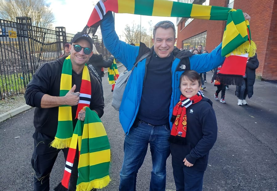 EXECUTIONAL sponsor team with football fans in scarves outside Old Trafford