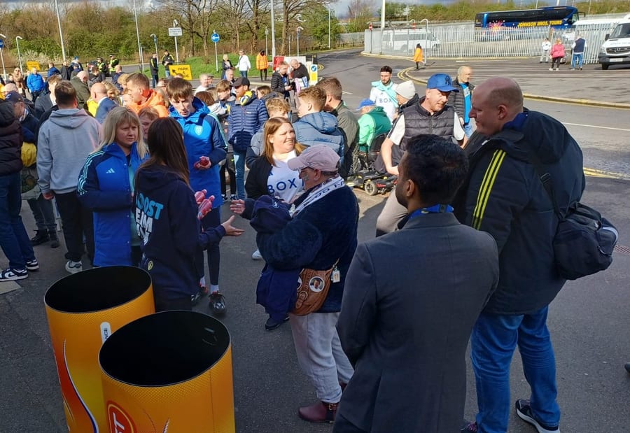 EXECUTIONAL team handing out sports drinks to fans on the approach to a stadium