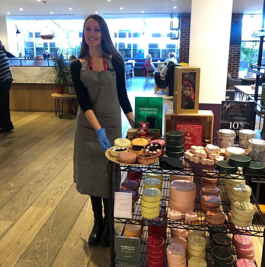 EXECUTIONAL food hall concession staff at a Charbonnel et Walker gift display