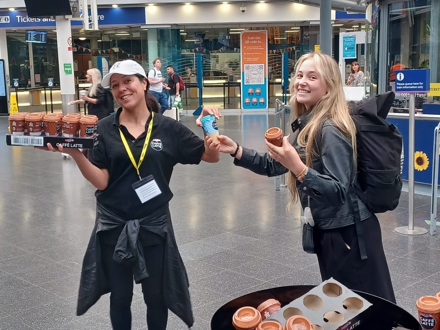 EXECUTIONAL samplers handing out Emmi Caffè Latte at Manchester Piccadilly station